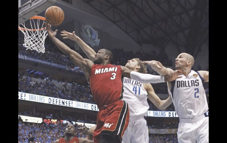 Dwyane Wade se cuela entre la marca de Dirk Nowitzki y Jason Kidd para anotar puntos en la canasta de los Mavericks. REUTERS  /