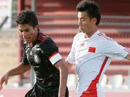 El tricolor Ulises Dávila protege la pelota ante la marca de Li Songyi de China. AP  /