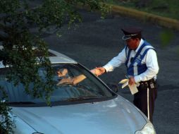 Un automovilista saluda a un agente de la Secretaría de Vialidad, una de las dependencias con más prácticas de corrupción. A. HINOJOSA  /