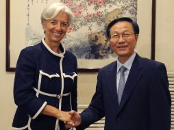 Christine Lagarde, estrecha la mano del Ministro de Finanzas chino, Xie Xuren. AFP  /