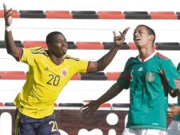 El delantero colombiano José Adolfo Valencia, celebra su anotación ante la decepción del mediocampista mexicano, Marvin Piñón. AP  /
