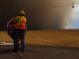 Un trabajador cierra un camino que conduce a la zona del incendio en Springerville, Arizona. AFP  /