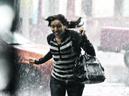 Una mujer corre para resguardarse de la lluvia que se presentó ayer de manera sorpresiva. E. PACHECO  /