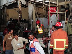 Voluntarios paquistaníes quitan a una de las  víctimas. AFP  /