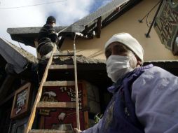 Dos hombres realizan tareas de limpieza  luego de las emanaciones del complejo volcánico chileno Puyehue-Cordón Caulle. EFE  /