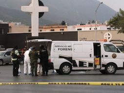 Policías y forenses en el sitio donde ayer se encontraron los cuerpos de los guardaespaldas del gobernador. AFP  /