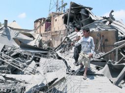 Niños libios caminan entre los escombros del hotel Wenzrik, que según el Gobierno libio fue bombardeado por la OTAN, en Trípoli. AP  /