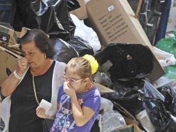 Una mujer y su hija pasan por una calle llena de montañas de desperdicios. EFE  /