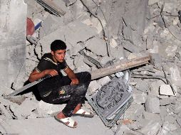 Un hombre libio descansa sobre escombros tras un ataque aéreo. EFE  /