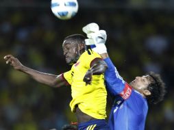 El colombiano Jackson Martínez y el arquero mexicano Luis Ernesto Michel disputan un balón. AP  /
