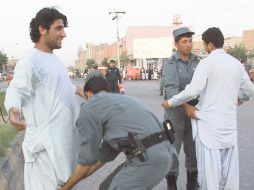Policías afganos registran a dos personas en el punto de control de Herat, Afganistán. EFE  /