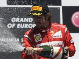 Fernando Alonso rociando champagne en la premiación. AFP  /