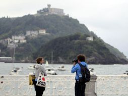En la imagen, dos turistas se fotografían junto a la playa de La Concha. EFE  /