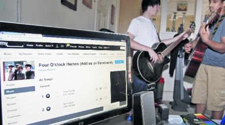 Jóvenes practican su música mientras tienen abierto el apartado del grupo en Myspace. ARCHIVO  /