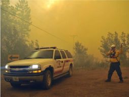 Las cuadrillas de bomberos quemaron arbustos para crear una franja contra incendios de 16 kilómetros. AP  /