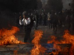 Manifestantes caminan junto a un fuego hoy, jueves 30 de junio de 2011, en las calles de Santiago. EFE  /