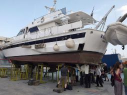 Los activistas examinan el eje de la hélice doblado de una embarcación que tiene previsto formar parte de la flotilla. EFE  /