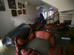 Xóchitl Cerón Velazco intenta rescatar algunas de sus pertenencias entre los muebles levantados por la inundación, en Iztapalapa. AP  /