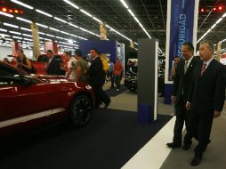Emilio González Márquez (derecha) recorre los pasillos de Expo Guadalajara, sede del Salón Internacional del Automóvil. M. FREYRÍA  /