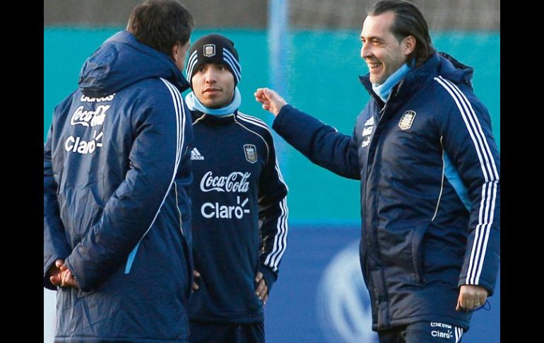 'Kun' (centro) platicó ayer al final de la práctica con el técnico Sergio Batista (der.) y sus auxiliares. AFP  /