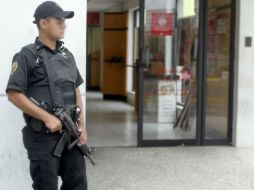 Elementos policiales resguardaron la sucursal bancaria para iniciar las indagatorias del caso. ARCHIVO  /