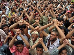 Manifestantes yemeníes antigobierno unen sus manos y gritan consignas demandando la salida de Saleh. EFE  /