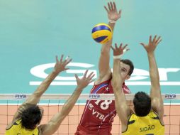 Los brasileños Gilberto Godoy Filho Giba (izda) y Sidao intentan bloquear el remate del ruso Alexandr Volkov. EFE  /