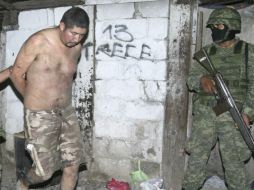 Un soldado acompaña al sujeto detenido que custodiaba la casa donde tenían a los plagiados. REUTERS  /
