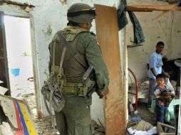 Un miembro de la policía camina dentro de una casa destruida luego de un atentado con coche bomba de las FARC. EFE  /
