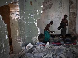 Dos jóvenes caminan sobre las ruinas de una casa derrumbada por el terremoto que sacudió a Haití en 2010. AFP  /