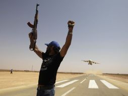 Un rebelde celebra el arribo de un avión a Rhebat, en el Sur de Trípoli. REUTERS  /
