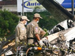 Dos peritos inspeccionan la aeronave calcinada en la ciudad de Recife, al noreste del país. EFE  /