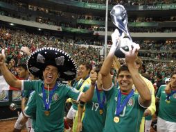 Carlos Fierro (der) cargando el trofeo y celebrando con sus compañeros. REUTERS  /