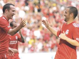 Joe Cole (der.) felicita a Charlie Adam, quien anotó un gol ayer con el Liverpool en Malasia. AFP  /