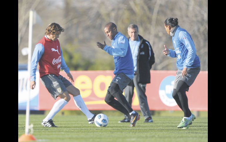 Diego Lugano (izq.) disputa la pelota con el atacante Abel Hernández ante la mirada del mediocampista Álvaro Pereira. AFP  /