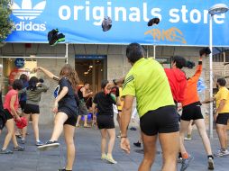 Un grupo de personas lanza su ropa hacia la puerta de la tienda de Adidas en la calle Fuencarral de Madrid. EFE  /