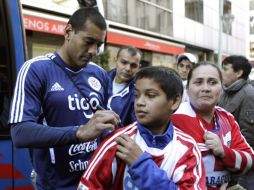 El defensa de Paraguay, Paulo da Silva, firma autógrafos para sus aficionados a las afueras de su hotel en Argentina. REUTERS  /