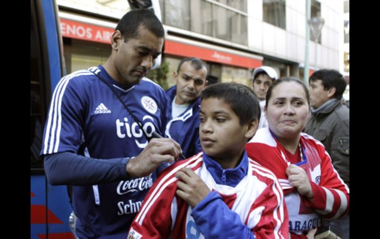 El defensa de Paraguay, Paulo da Silva, firma autógrafos para sus aficionados a las afueras de su hotel en Argentina. REUTERS  /