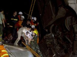 Socorristas tratan de ingresar al vagón que quedó suspendido en el aire para rescatar a los pasajeros. AFP  /