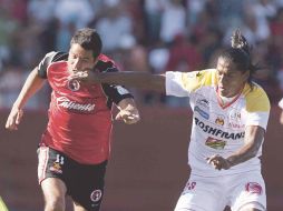 Luis Orozco (Xolos) y Joel Huiqui (Monarcas) pelean un esférico. MEXSPORT  /