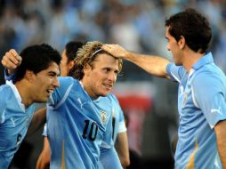 Diego Forlán (C) celebrando el tercer gol de Uruguay con sus compañeros Diego Rodin (D) y Luis Suárez. AFP  /