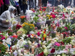 Una mujer enciende una vela en Oslo en memoria de las víctimas de los ataques en Noruega. AFP  /