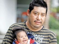Miguel sostiene al menor de sus hijos, del que su esposa tenía ocho meses de embarazo al suceder el accidente. EL UNIVERSAL  /