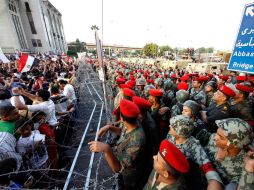 Manifestantes permanecen frente al alambre de púas que instalaron las Fuerzas de Seguridad egipcias para frenar la marcha. EFE  /