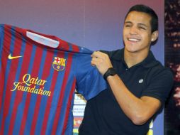 El jugador chileno Alexis Sánchez, muestra la camiseta del Fc. Barcelona en el Camp Nou. EFE  /