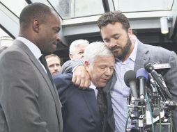Jeff Saturday (der.), y Robert Kraft (centro), se funden en un abrazo, que simboliza las paces entre jugadores y dueños. AFP  /