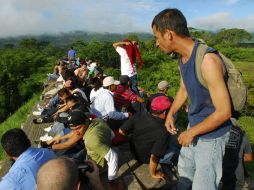 Decenas de inmigrantes y activistas  viajan por tren tras abordarlo en Tenosique, Tabasco, hacia la capital del país. EFE  /