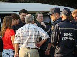 Miembros de los servicios de emergencia conversan con varias personas cerca de la mina de carbón de Sujodólskaya-Vostóchnaya. EFE  /