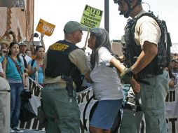 Policías detienen a una activista durante la manifestación. AP  /