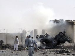 Varios policías se congregan en los alrededores del lugar donde hizo explosión un coche bomba en Lashkargah. EFE  /